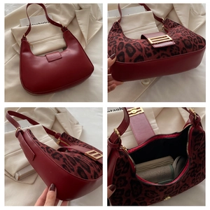 Detalle del bolso rojo con estampado de leopardo mostrando el interior y hebillas doradas