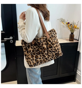 Detail of leopard print faux fur tote bag with brown leather shoulder straps on model