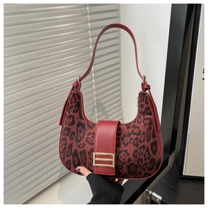 Detalle del bolso rojo de leopardo con hebilla metálica y textura de gamuza suave