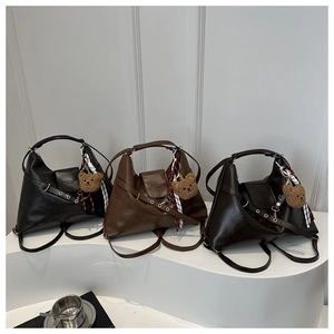 Vue détaillée de trois sacs cabas vintage en noir et marron avec breloques d'ours