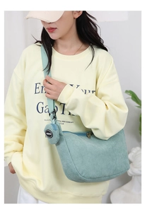 Detail of mint green corduroy crossbody bag with matching round coin purse on strap