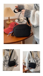 Détail de la sacoche noire en nylon imperméable avec poche zippée et sangle réglable