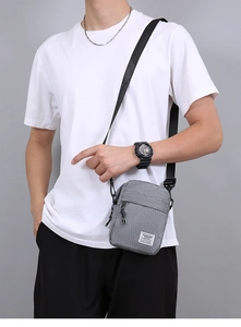 Dettaglio della borsa a tracolla in nylon grigio con cinturino regolabile e patch