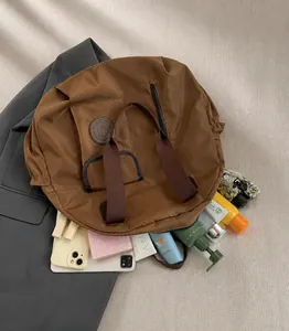 Vista dall'alto di una borsa in nylon marrone con ampio interno per i cosmetici