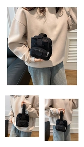 Detail of cute black cartoon backpack for kids with eye patches and silver zipper closure