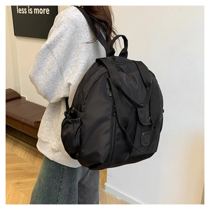 Dettaglio dello zaino nero in nylon con spallacci ergonomici e tasche laterali funzionali