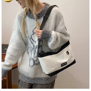 Dettaglio di una borsa a tracolla minimalista in tela bianca e nera con cinturino