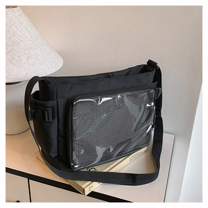 Detail of black ita bag featuring a large clear PVC window and adjustable buckle strap