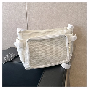 Detail of white nylon tote bag with mesh front pocket and plastic buckle closure