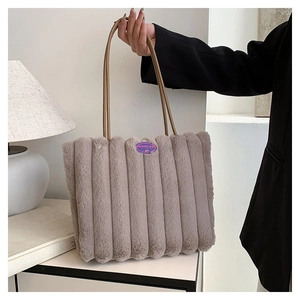 Détail du sac cabas en peluche gris-violet avec poignées en cuir et badge de mode
