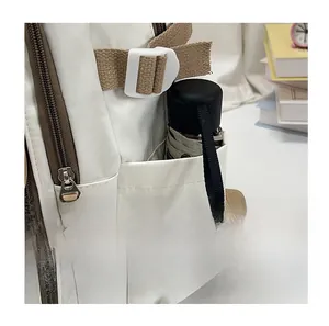 Detail shot of the side pocket on a nylon backpack holding a black folding umbrella