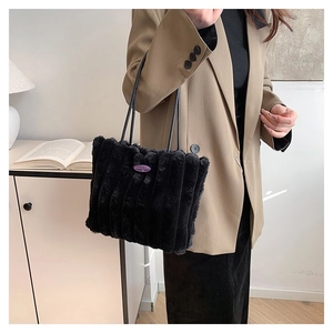 Détail du sac cabas en peluche noire avec texture douce et anses en cuir