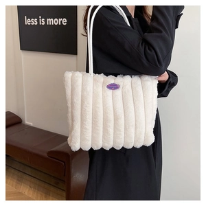Détail du sac cabas en peluche blanche avec rayures verticales et étiquette de mode
