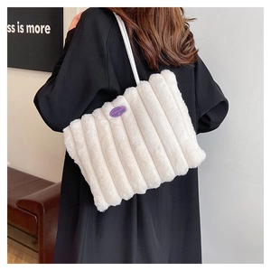 Détail de sac fourre-tout en peluche blanche avec rayures verticales et étiquette mode