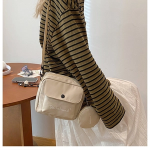Detailed shot of beige canvas crossbody bag with Dachshund print and small coin purse pouch