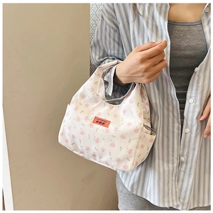 Close-up of white floral lunch bag with pink flower pattern and red brand label