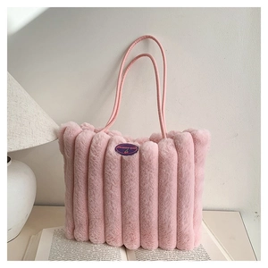 Détail du cabas en peluche rose avec surpiqûres verticales et écusson logo cerise élégant