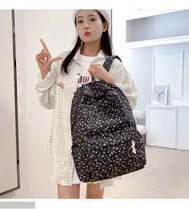Close-up of black floral canvas backpack featuring pink and blue flower patterns