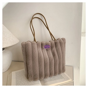 Détail du sac fourre-tout en peluche avec texture côtelée et anses en cuir élégantes