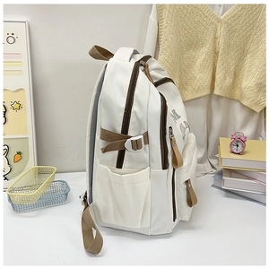 Side view of white canvas backpack with brown straps in a cozy student study setting