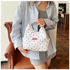 Close-up of lightweight floral canvas lunch bag featuring red brand label and pattern