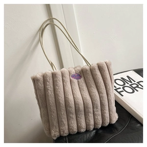 Détail d'un sac cabas en peluche avec matelassage vertical et broderie violette