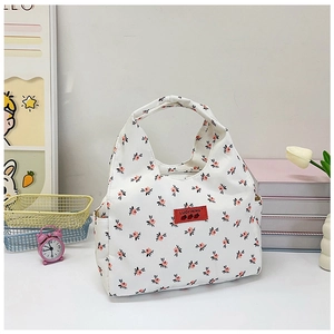 Detailed view of floral canvas lunch bag with side pockets and a sturdy top handle