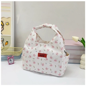 Detail showing pink floral lunch bag with side pockets and red embroidered label