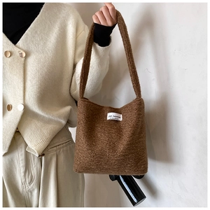 Dettaglio texture della borsa in peluche marrone con etichetta Love Fashion