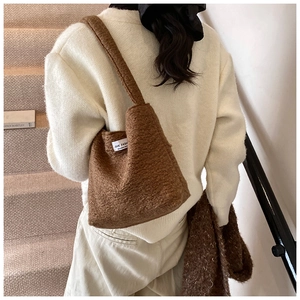 Vista dettagliata della borsa a spalla in pile marrone con etichetta Love Fashion su modella
