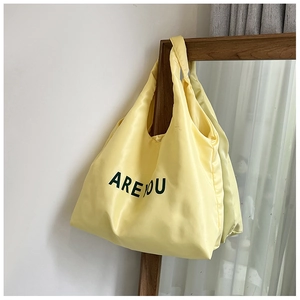 Detalle del bolso tote amarillo claro satinado con el estampado gráfico ARE YOU