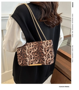Détail du sac bandoulière léopard avec chaîne dorée et finitions métalliques chic