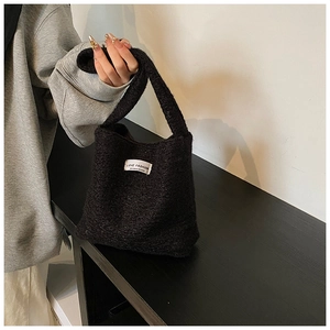 Dettaglio della borsa in sherpa nera con texture morbida ed etichetta Love Fashion
