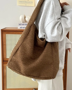 Detailopname van de bruine teddy fleece draagtas met een zachte pluche textuur