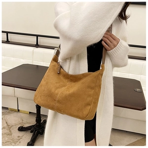 Close-up of brown suede hobo bag featuring contrast white stitching and leather strap