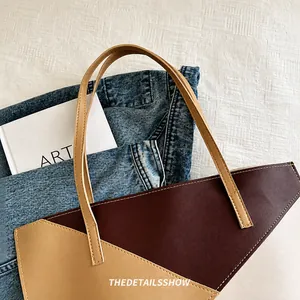 Dettaglio della borsa tote bicolore marrone e beige con manici sottili e cuciture a vista