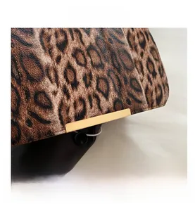 Détails de la texture léopard en similicuir avec bordure dorée et doublure noire