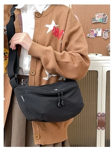 Detail of black nylon crossbody bag featuring double zippers and fashion logo label