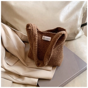 Dettaglio della trama di una borsa in peluche marrone con etichetta tessuta LOVE FASHION