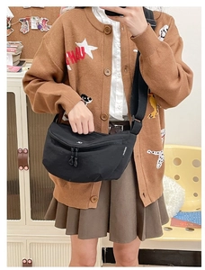 Close-up of black nylon crossbody bag with adjustable strap shown in a daily casual style