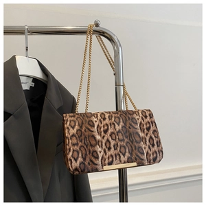 Detalle de bolso de leopardo con correa de cadena dorada y adornos metálicos