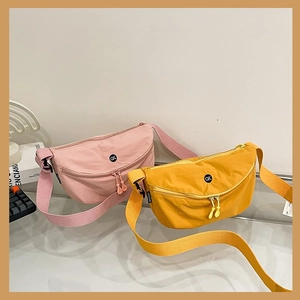 Detail of pink and yellow canvas crossbody bags with adjustable straps and OK logo