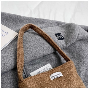 Dettaglio borsa in peluche marrone con logo Love Fashion bianco e morbido tessuto