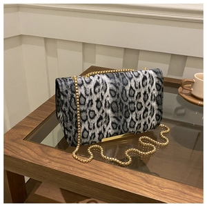Detalle de textura de leopardo y cadena dorada en un bolso bandolera de moda