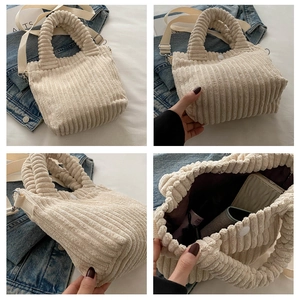 Detail of beige corduroy bucket bag showing texture, snap closure and inner space