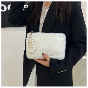 Detail van witte pluche handtas met grote parelmoeren handgreep en zacht imitatiebont