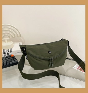 Detail of army green nylon crossbody bag with dual-way zipper and adjustable strap