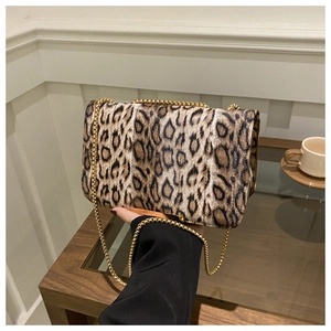 Detalle de bolso bandolera de ante con estampado de leopardo y cadena de metal dorado