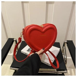 Detail of red heart-shaped PU leather bag with pleated design and golden lettering