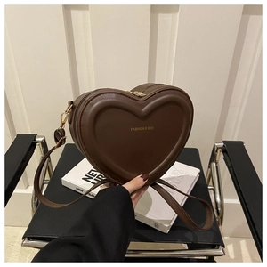 Detail of heart-shaped brown leather shoulder bag with gold FASHION & BAG lettering